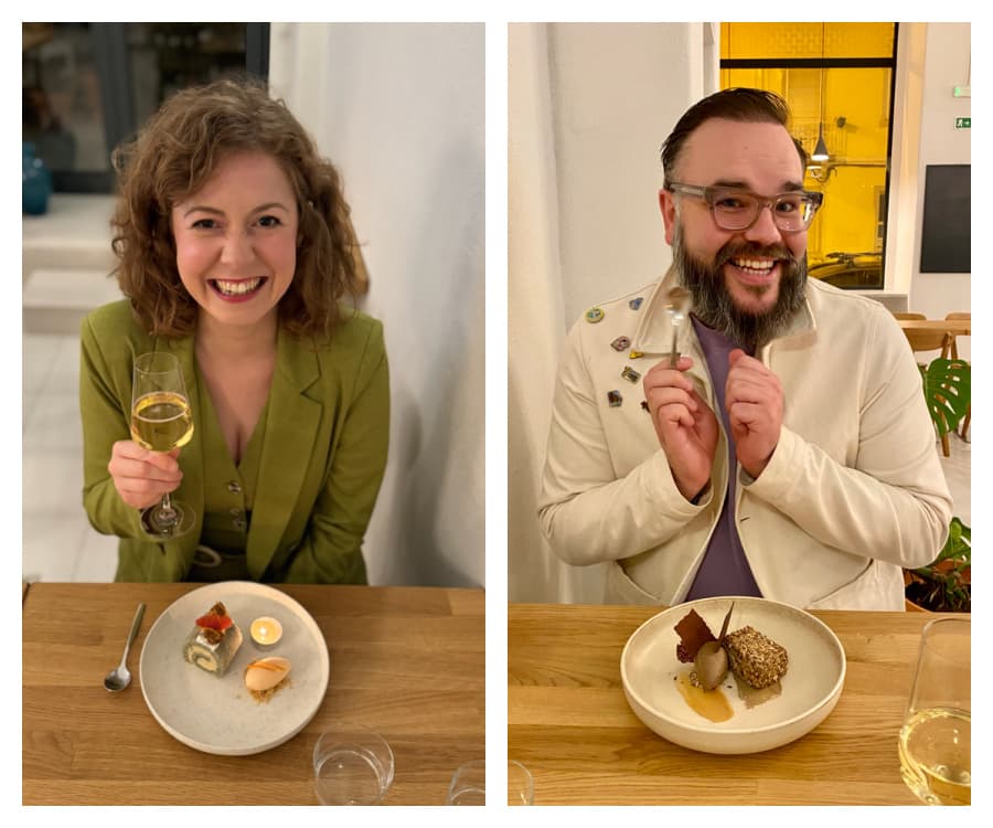Elly McKeown and Pascal Pixel sat at a table in a restaurant eating dessert and smiling  